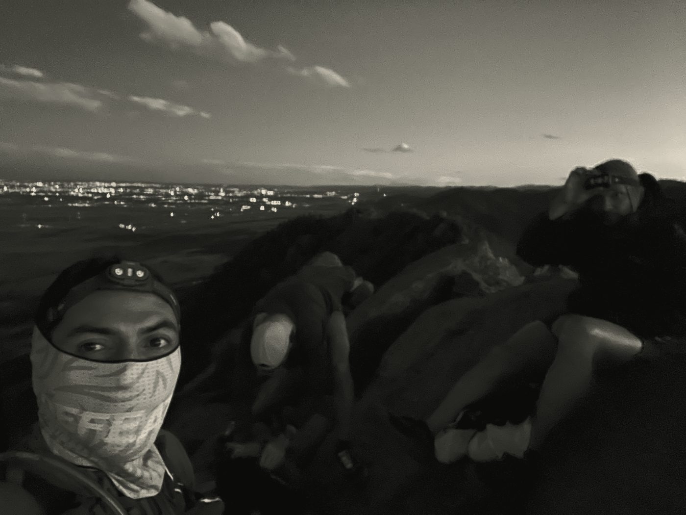 Crew on a dawn summit above the city lights