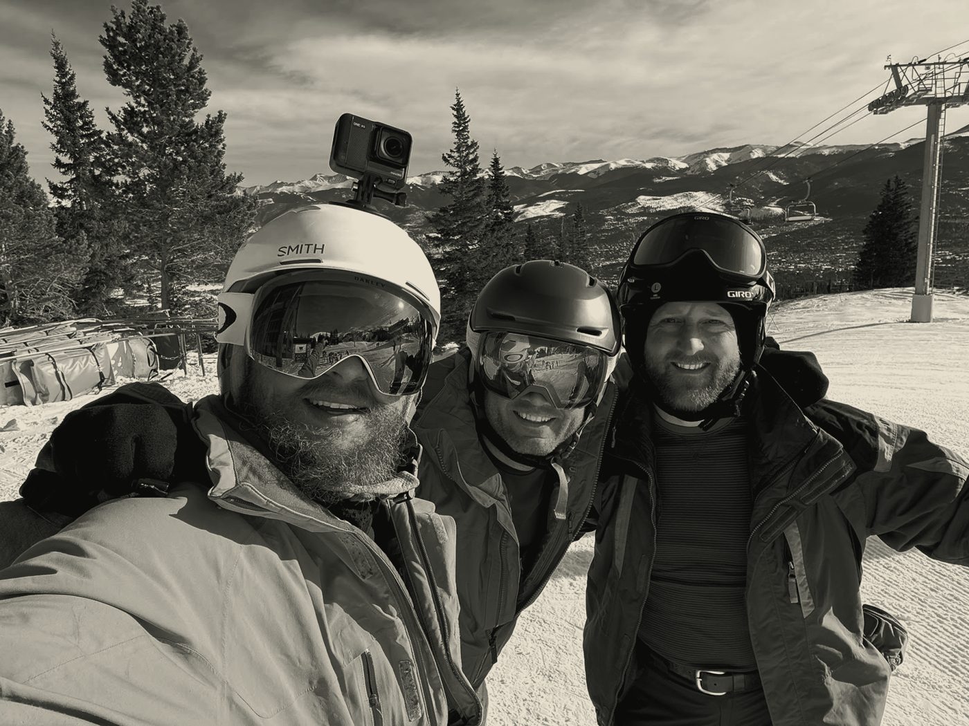 Three men in ski gear at the base of a mountain